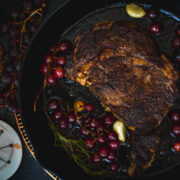 Steak with blistered grapes in a cast iron pan