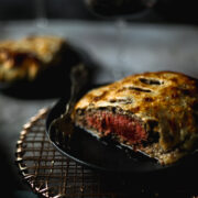 A photo of beef wellington served with red wine
