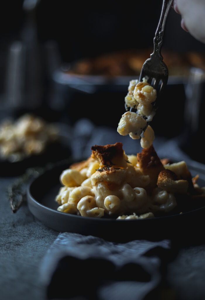 a plate of smoked gouda mac and cheese with someone grabbing a forkful