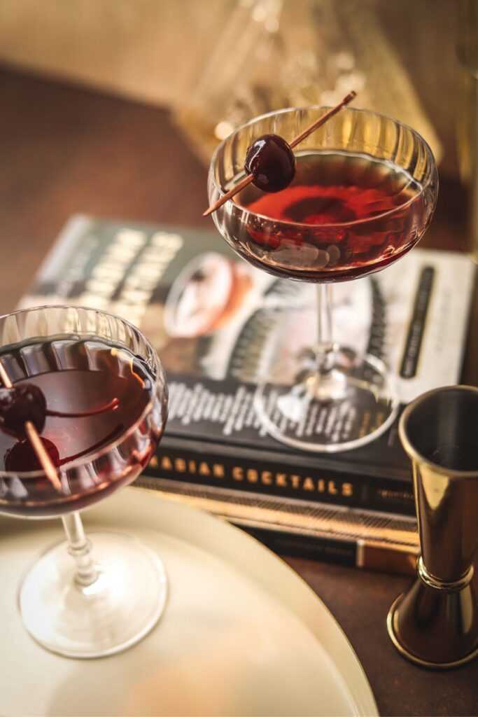 A manhattan cocktail on some cocktail books.