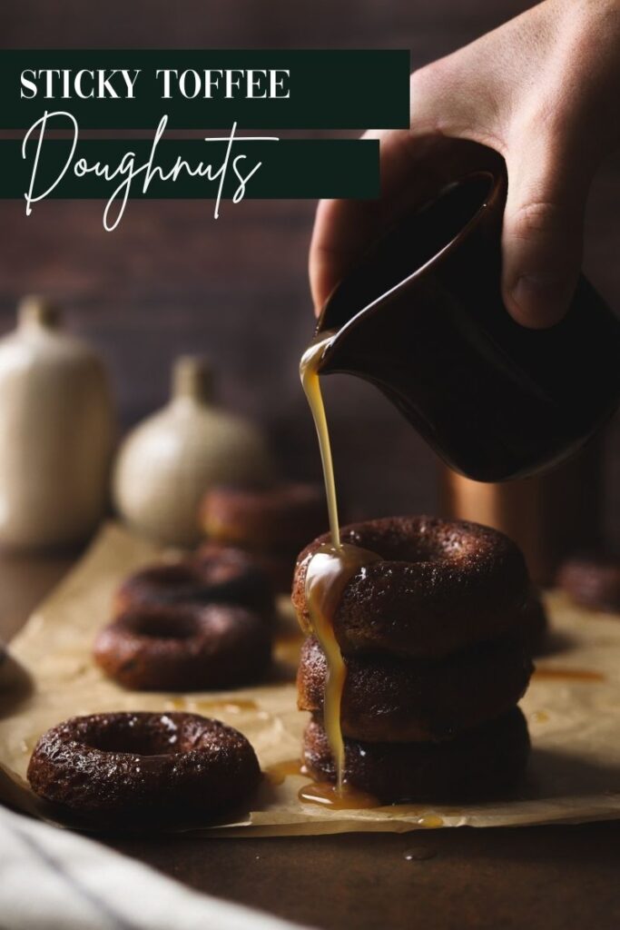 A photo of three sticky toffee doughnuts with sauce being poured on them