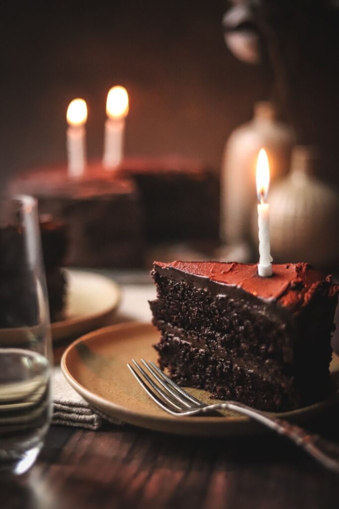 A picture of the best moist chocolate cake with candles and a fork