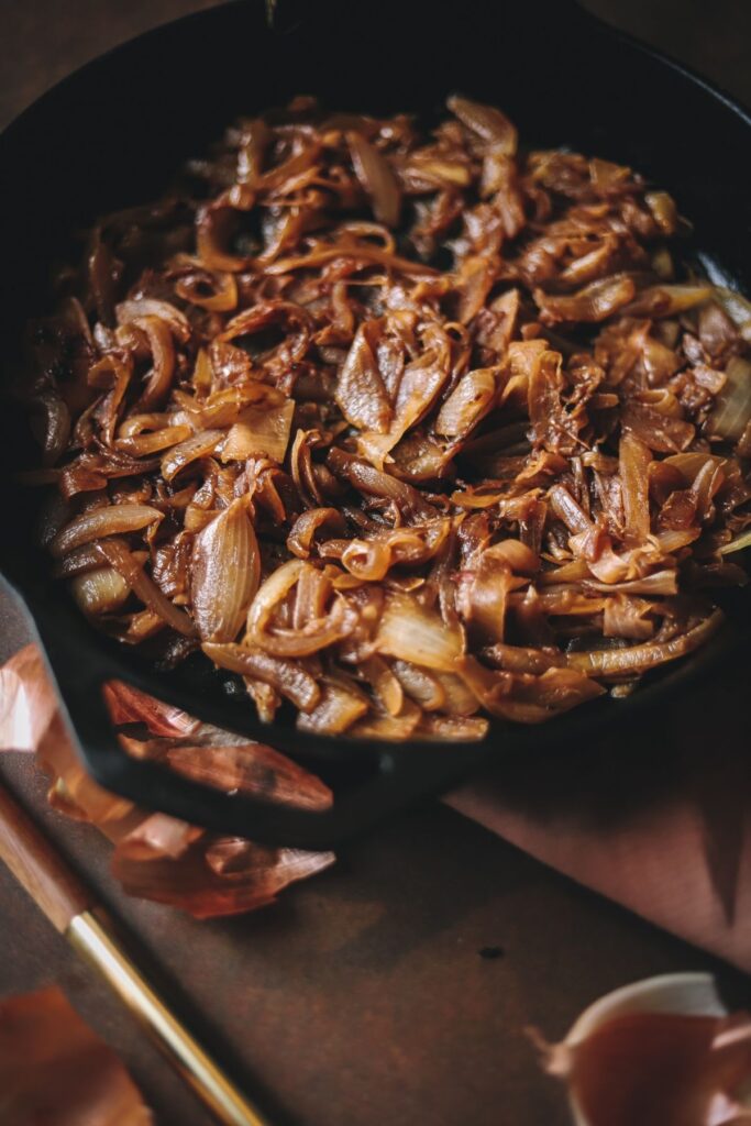 A close up photo of caramelized onions in a cast iron skillet
