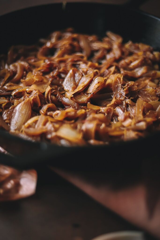 A close up photo of caramelized onions in a cast iron skillet