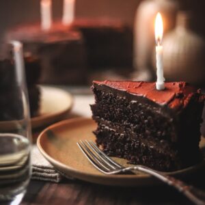 A picture of the best moist chocolate cake with candles and a fork