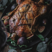 Photo of a whole roasted duck with figs and sage