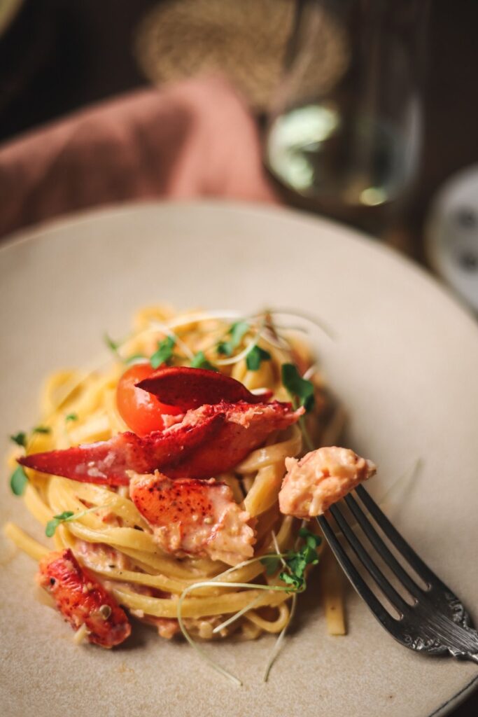 A close up of a plate of lobster pasta with champagne sauce