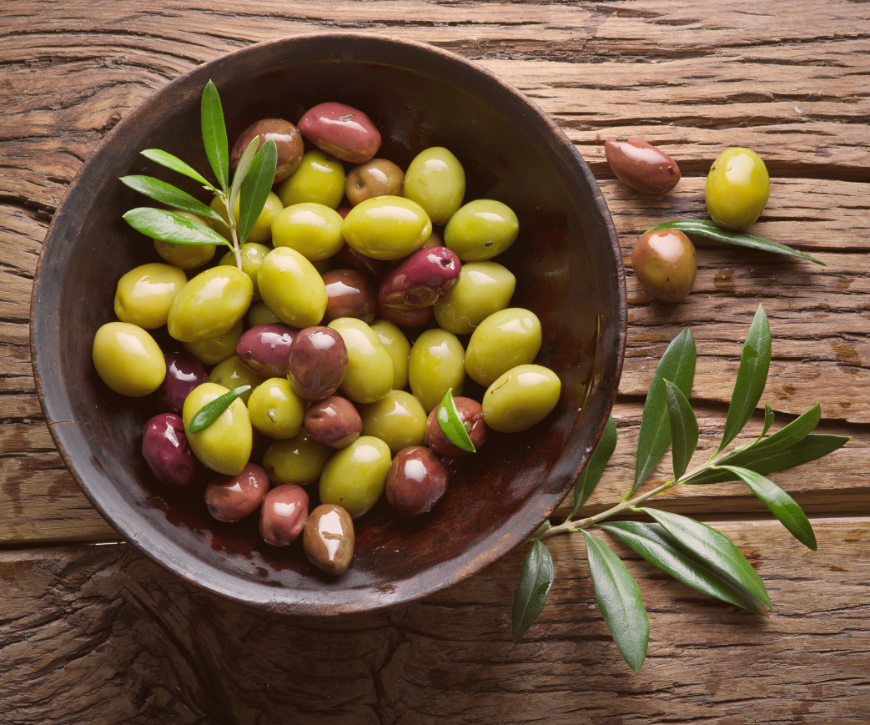A bowl full of black and green olives