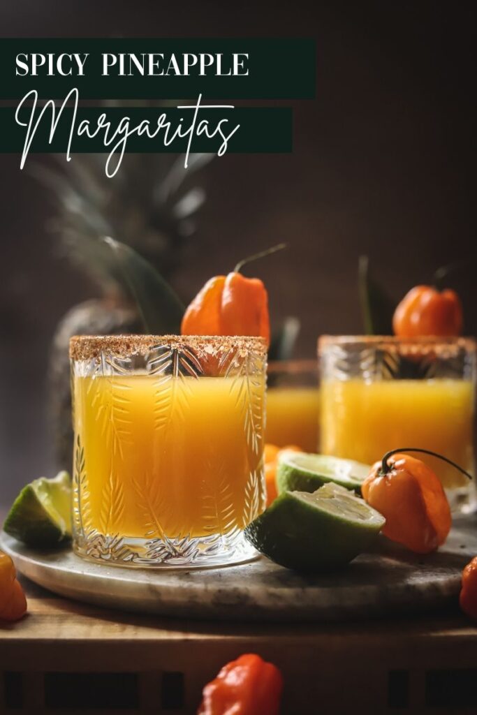 A photo of three spicy pineapple margaritas with habanero peppers