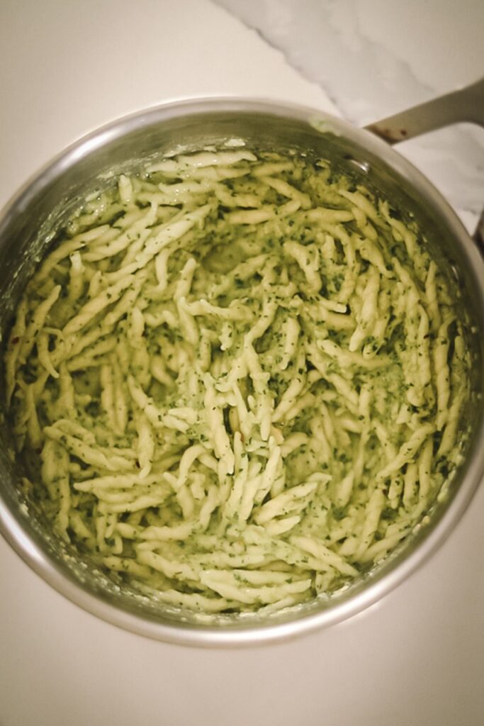 A pot full of the pasta with the pesto.