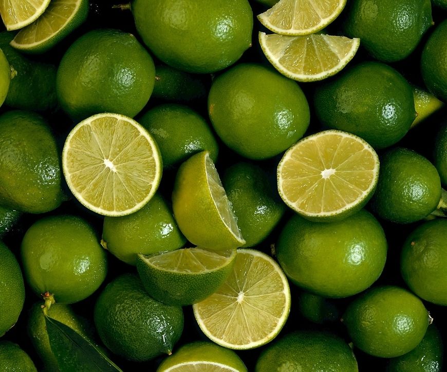 A pile of limes, some cut in half