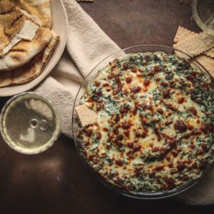 A photo of crab spinach dip with pitas and white wine