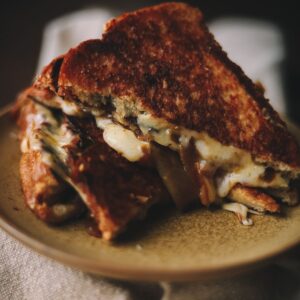 A photo of triple decker grilled cheese with caramelized onions