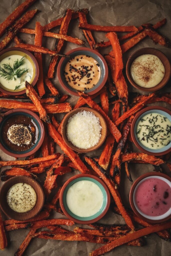 Nine different dipping sauces surrounded by sweet potato fries