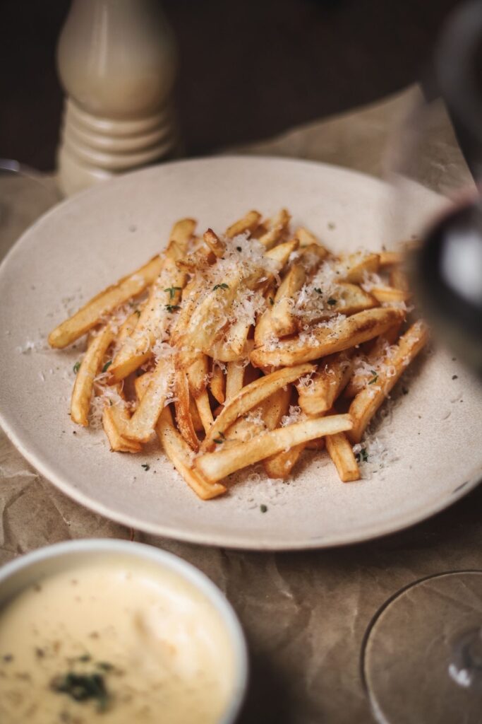 a photo of truffle parmesan fries and dipping sauce, and red wine