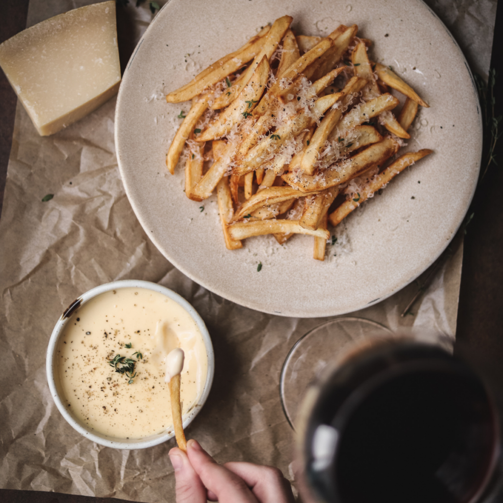 A photo of truffle parmesan fries with aioli and red wine