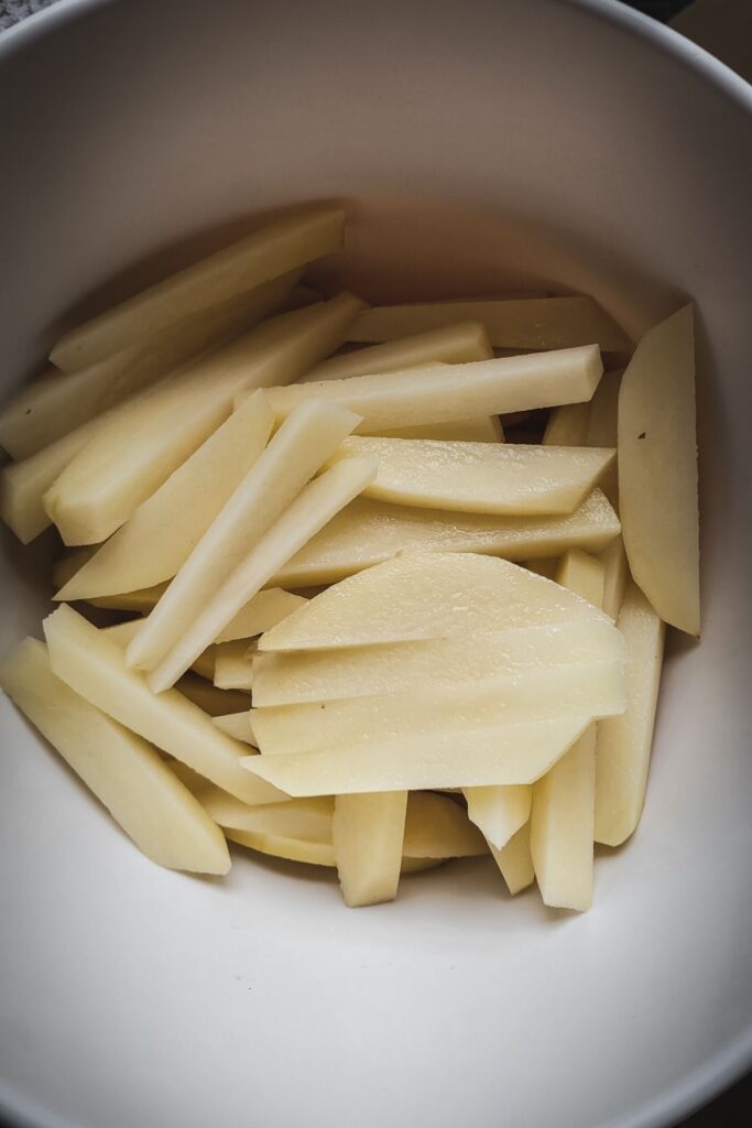 A photo of uncooked French Fries in a bowl