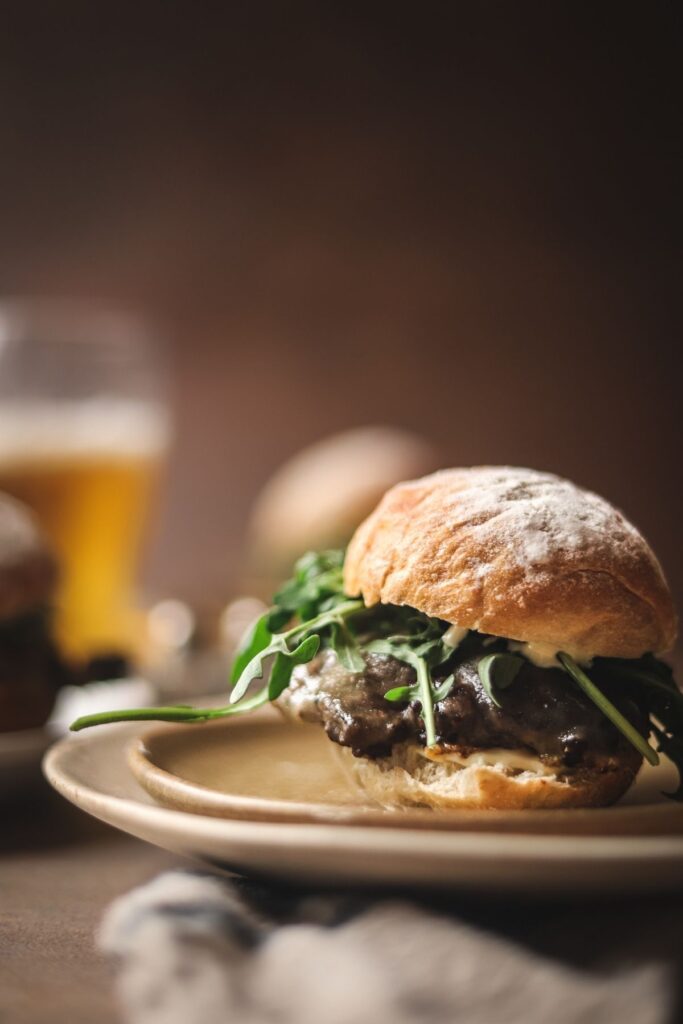A wagyu smash burger with arugula, cheese and truffle oil