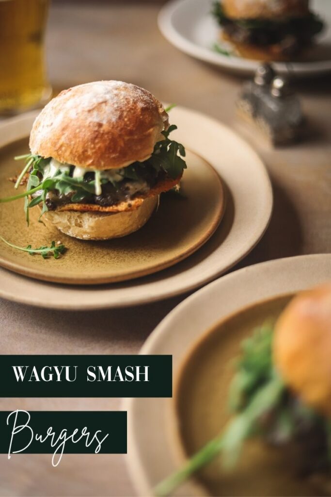 A photo of three wagyu burgers with title text