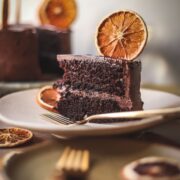 Slices of orange chocolate cake with dehydrated oranges.