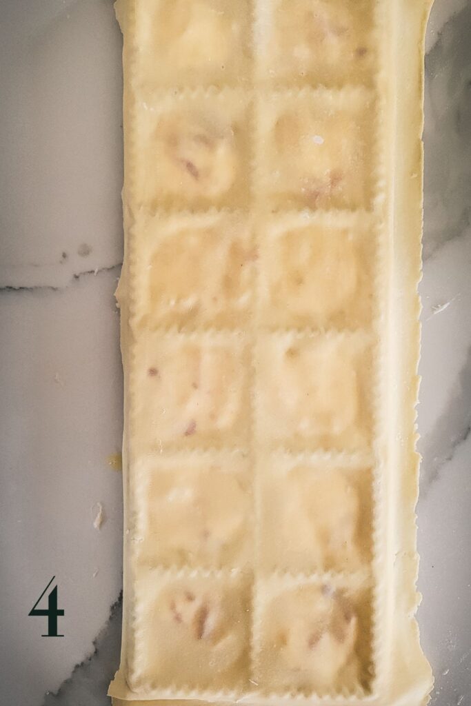 A ravioli maker with the top sheet of pasta on