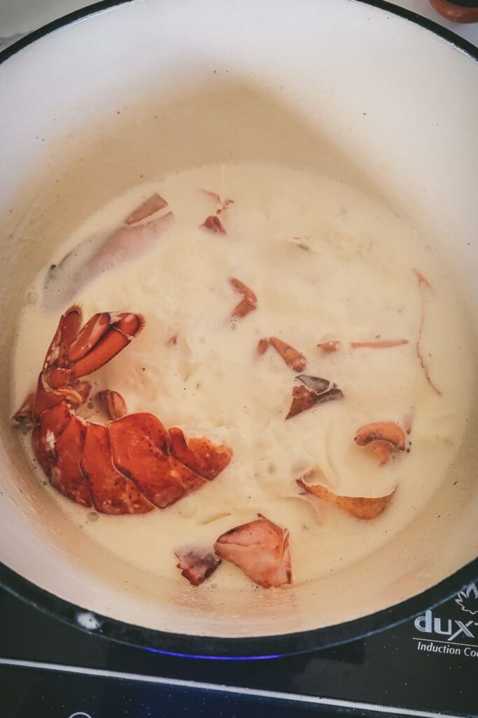 Lobster shells and cream simmering in a dutch oven.