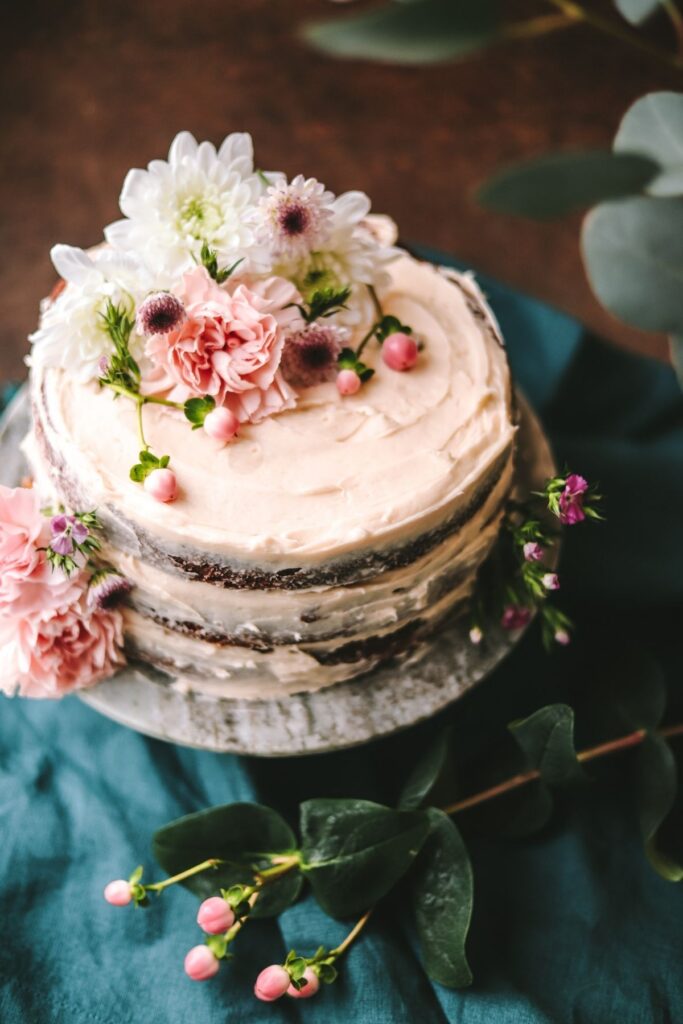 A photo of old-fashioned carrot cake decorated with spring flowers.