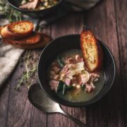 A photo of white bean and ham soup with crostini