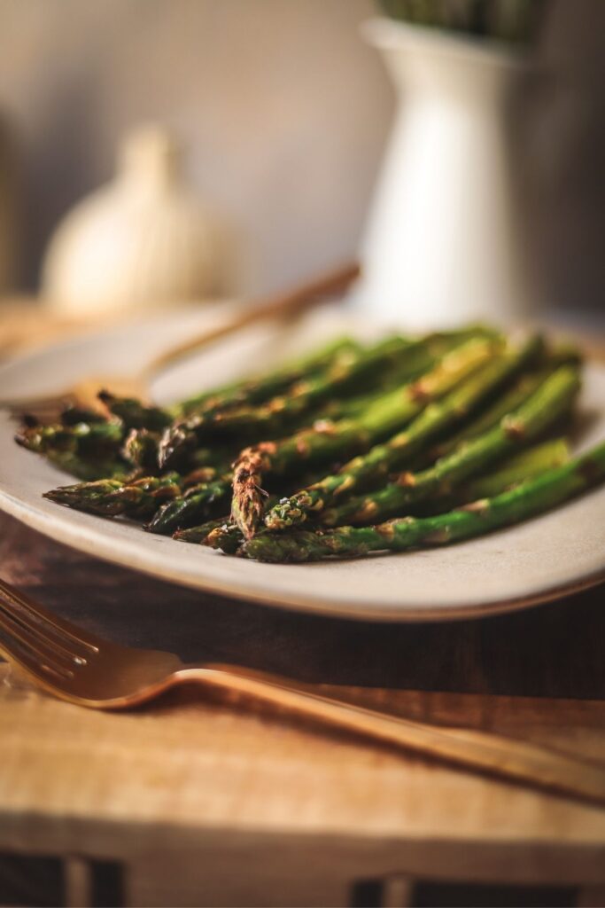 A photo of a plate full of broiled asparagus