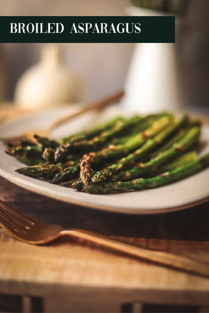 Broiled asparagus being served on a plate.