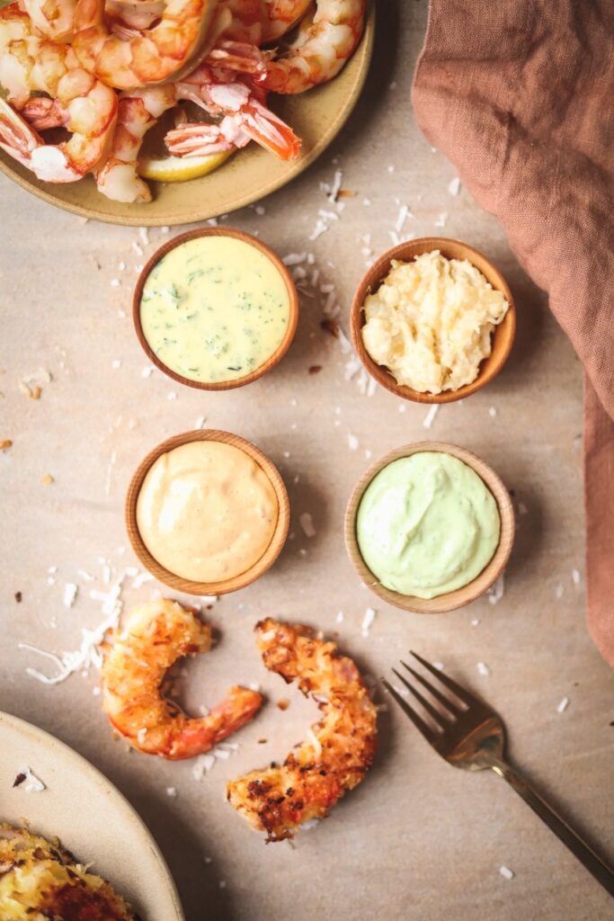 A photo of four different dips for shrimp