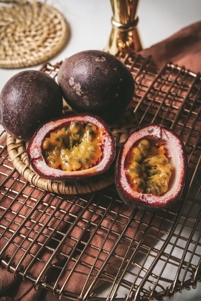 A photo of passion fruit, one cut open.