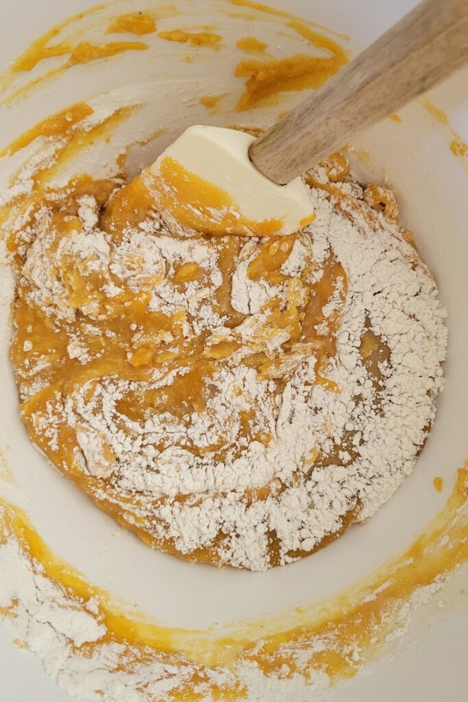 Wet and dry ingredients partially mixed with a spatula. 