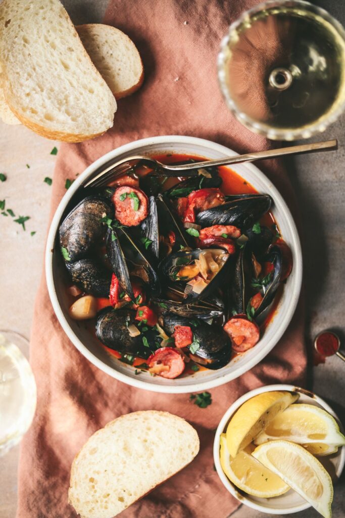 A bowl of Spanish mussels with bread and wine. 