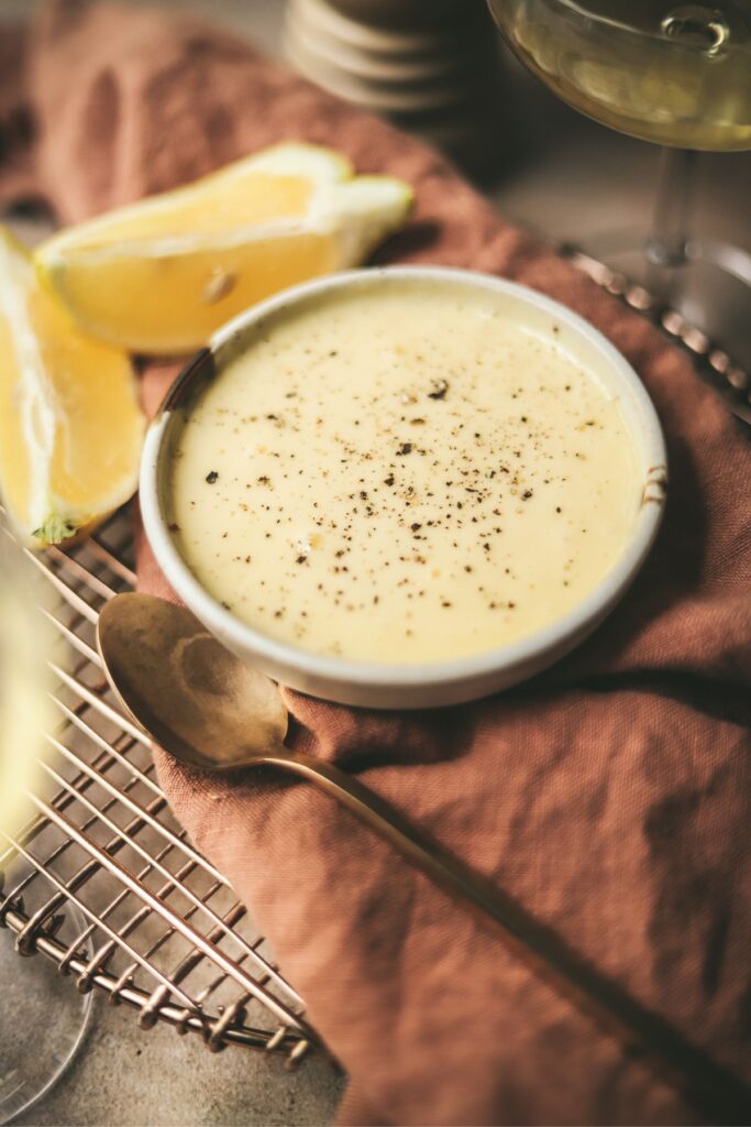 A photo of a small bowl of truffle aioli with lemons