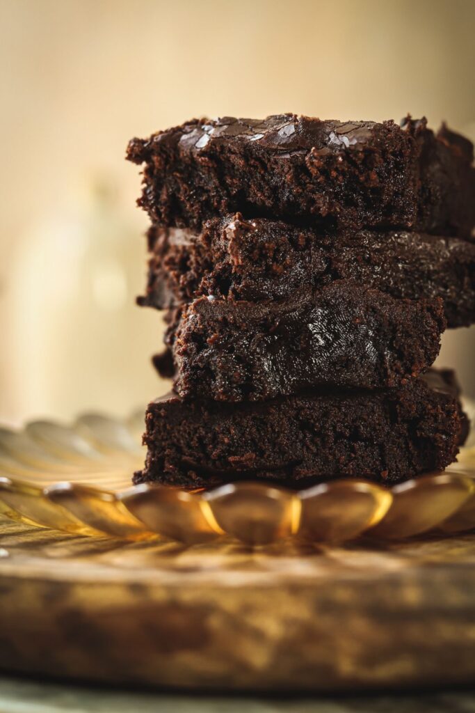 four chocolate gooey brownies stacked on top of each other