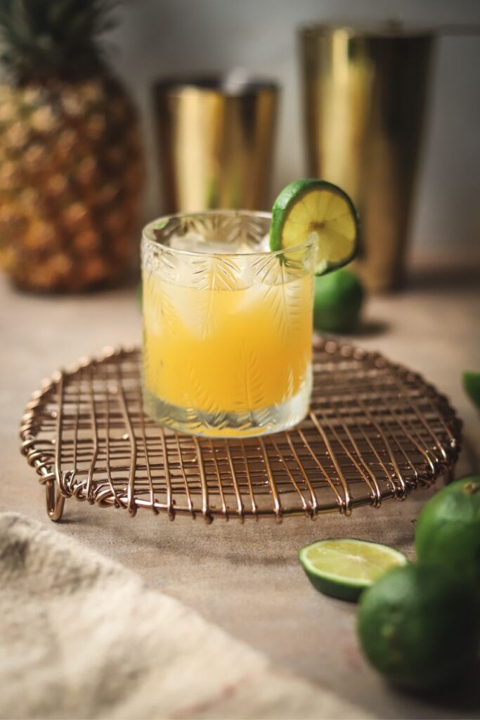 A mango tango cocktail garnished with lime. 