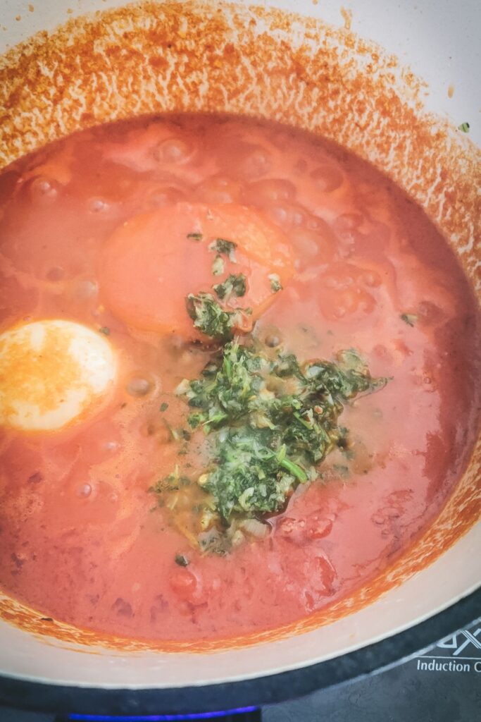 Tomatoes and oil added to the pot.