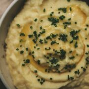 Bowl of mashed potatoes, chives, butter.