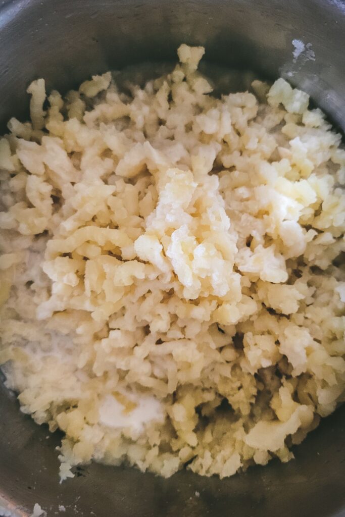 Mashed potatoes in a pot that have been riced.