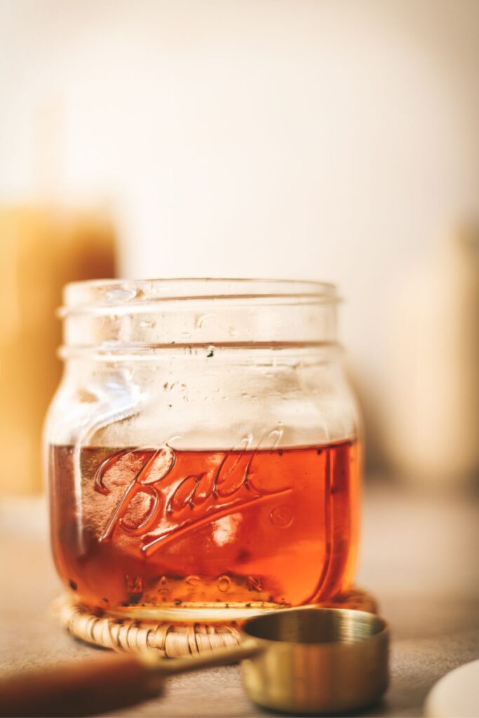 A jar of deep amber colored vanilla syrup. 