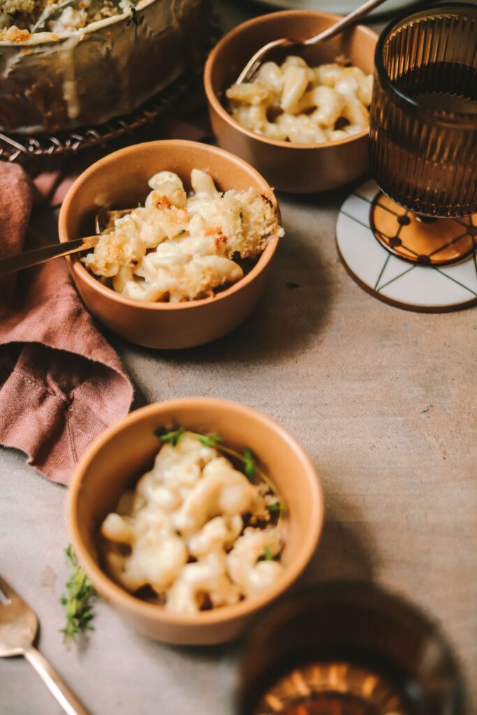 Three bowls of brie mac and cheese with vintage glasses. 