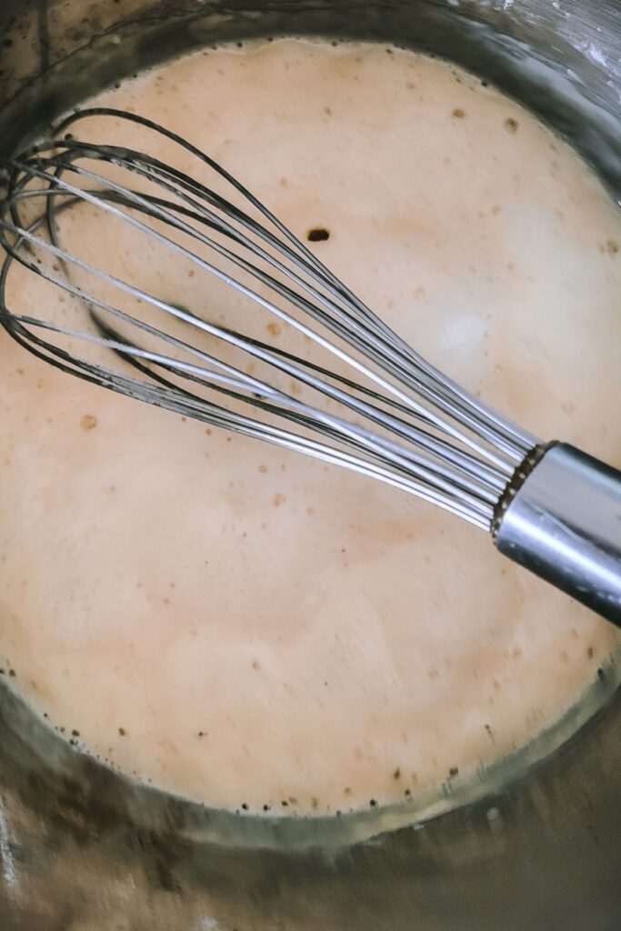 The roux bubbling with a whisk inside. 