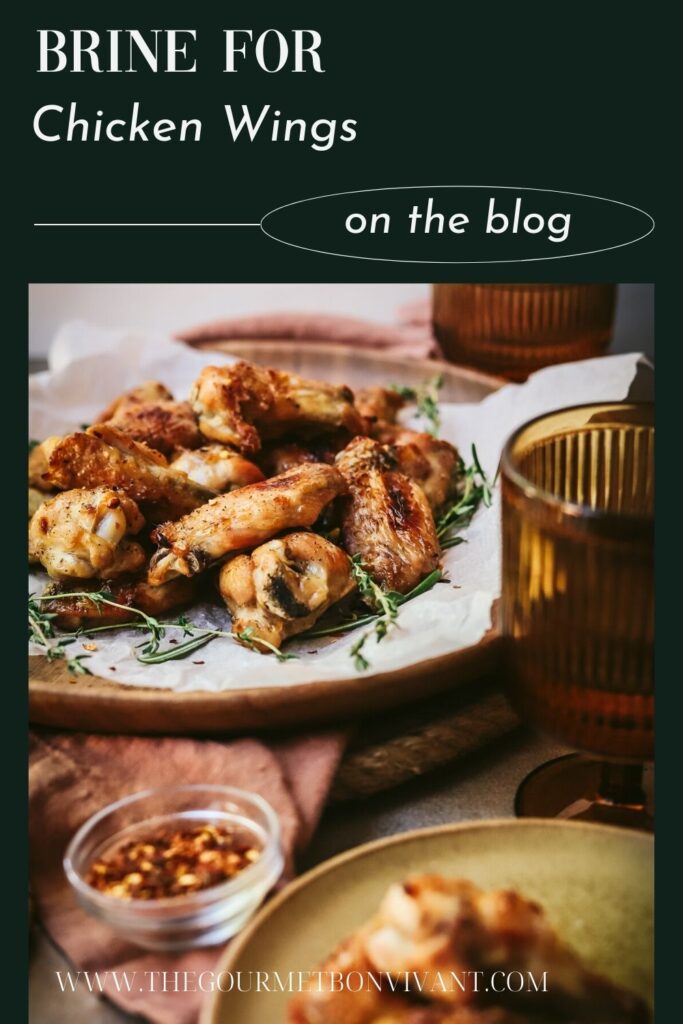 Platter of chicken wings with wine glasses and title text.