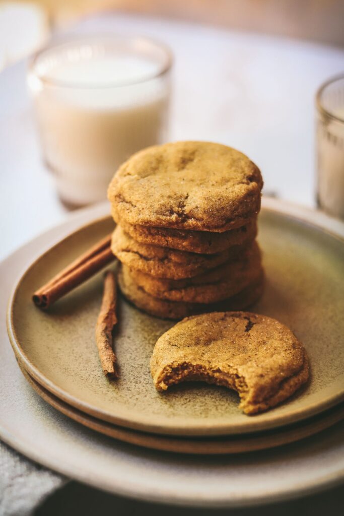 A stack of pumpkin snickerdoodle cookies with a bite out of one of them. 