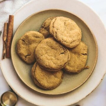 A plate of pumpkin snickerdoodle cookies with milk and spices.