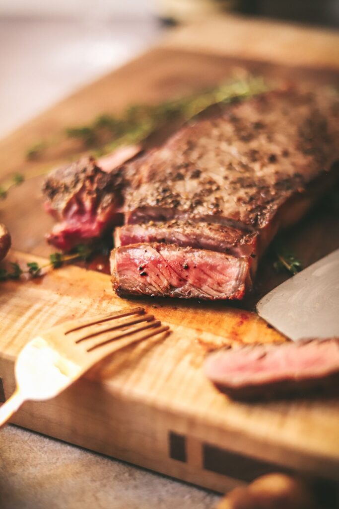 A photo of a steak sliced on a cutting board.