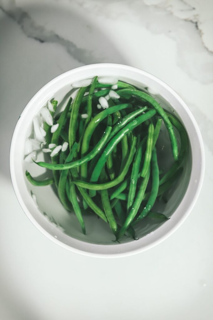 Green beans in a bowl filled with ice water. 