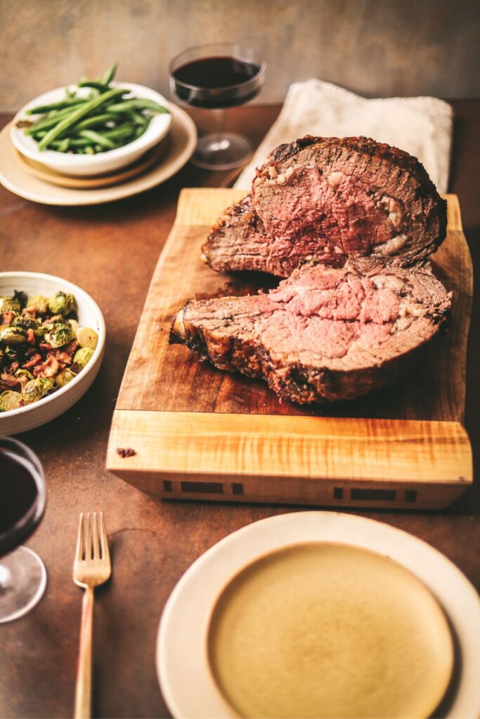 Prime rib roast with side dishes and red wine. 