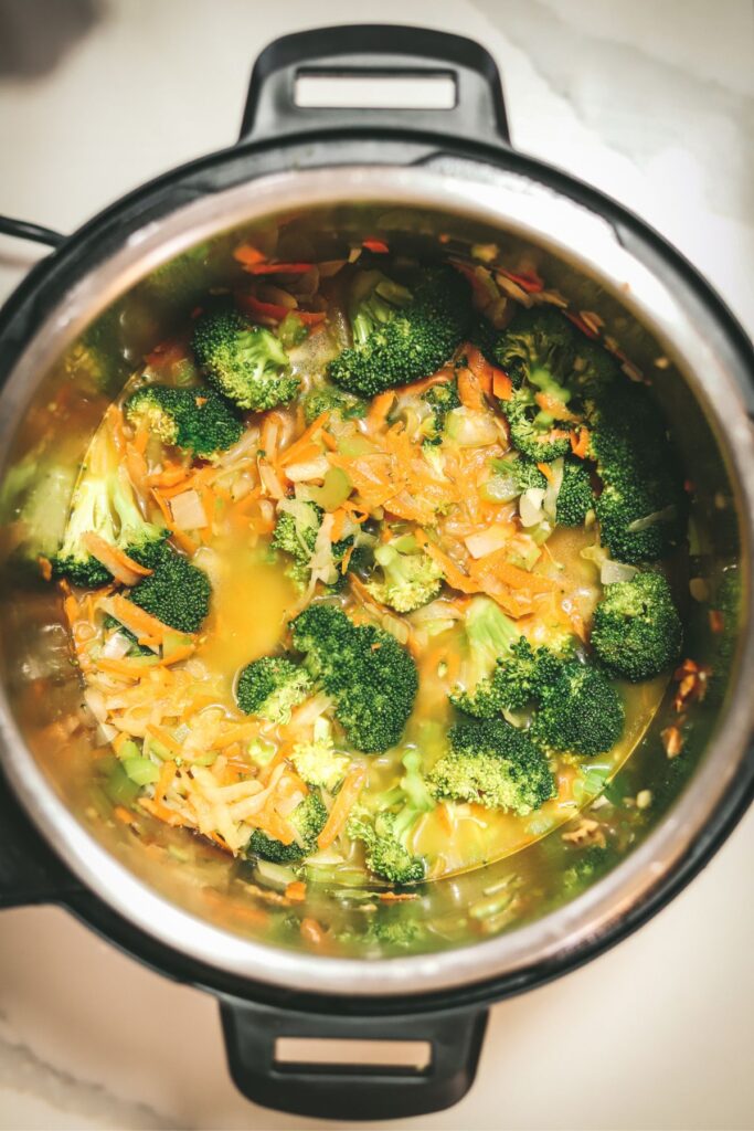 Process of making the soup - adding the broth and broccoli to the instant pot. 